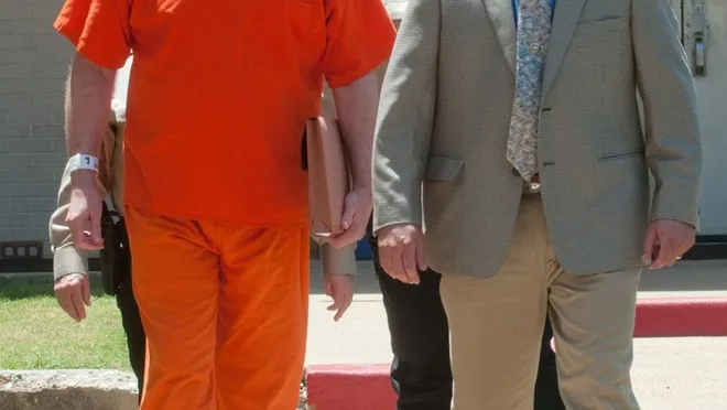 Bernie escorted by prison officials